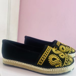 Mocasín bordado de color negro y oro.
